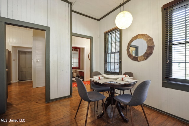 dining area featuring wood walls and dark hardwood / wood-style floors