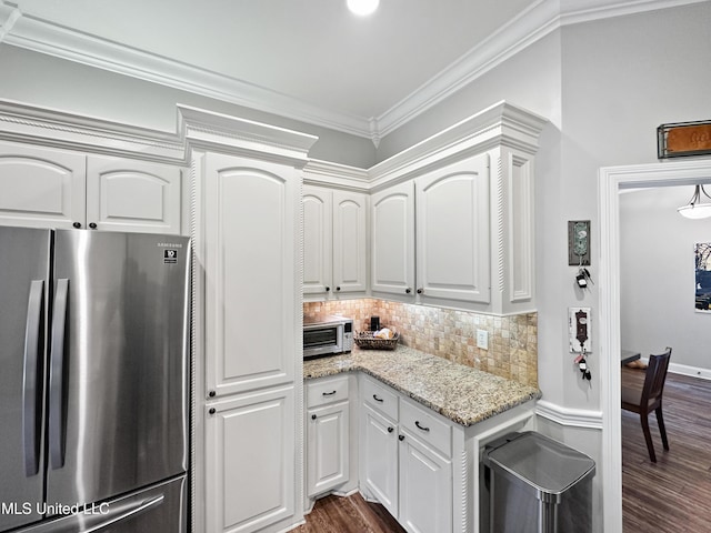 kitchen with freestanding refrigerator, white cabinetry, dark wood-style floors, and tasteful backsplash