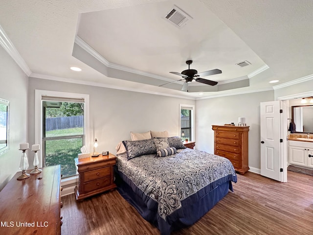 bedroom with visible vents, a raised ceiling, and dark wood-type flooring