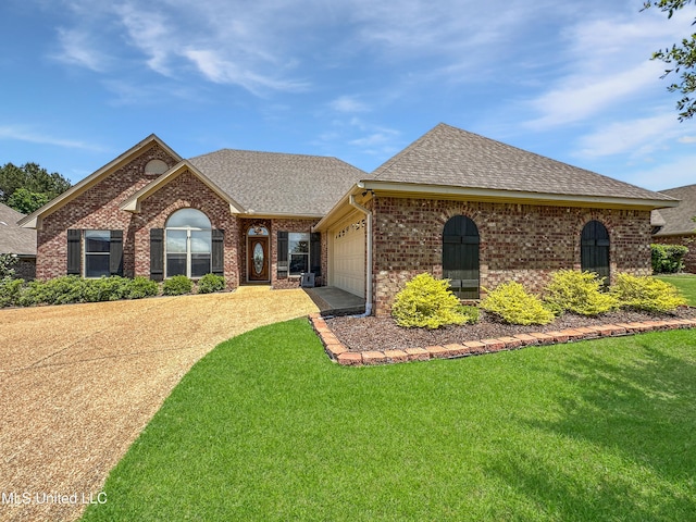 ranch-style home featuring a front lawn, brick siding, a shingled roof, concrete driveway, and an attached garage