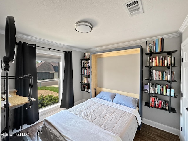 bedroom with crown molding, multiple windows, wood finished floors, and visible vents