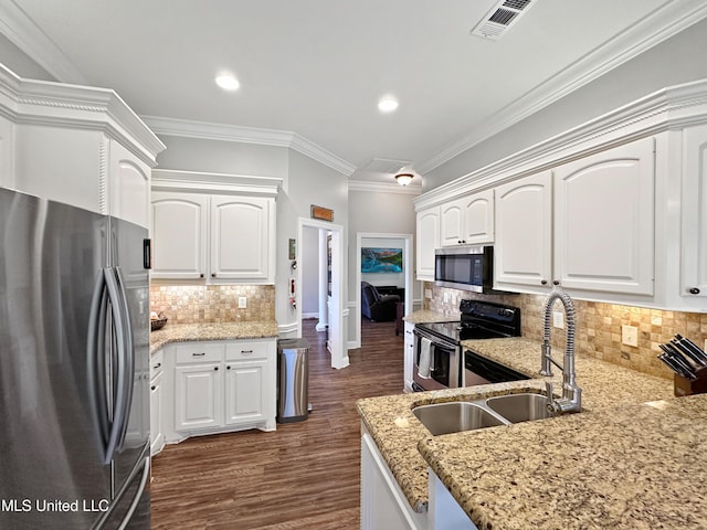 kitchen featuring stainless steel appliances, light stone counters, decorative backsplash, and a sink