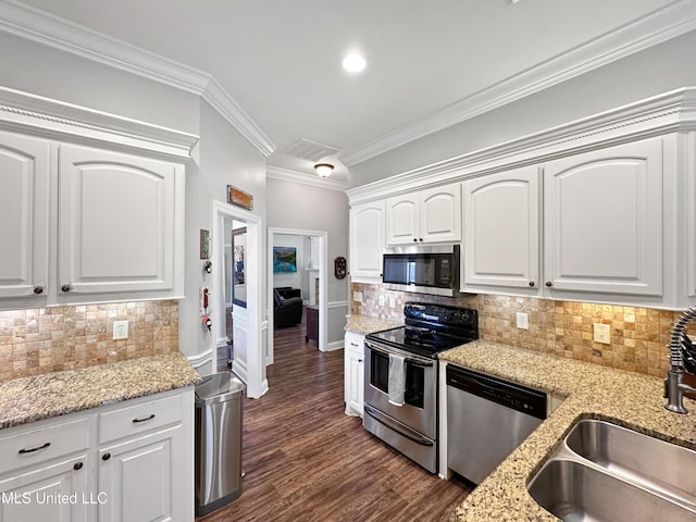 kitchen featuring a sink, decorative backsplash, stainless steel appliances, and white cabinetry