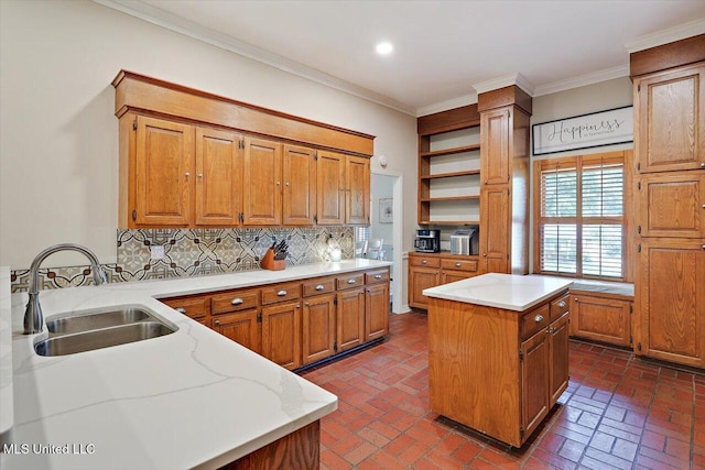121 Countrywood Cir, Clinton, MS 39056 - kitchen featuring a sink, brown cabinetry, decorative backsplash, a kitchen island, and ornamental molding