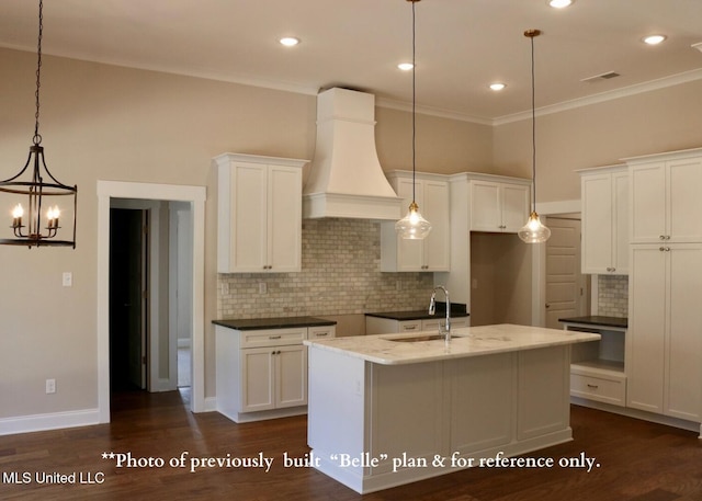 6579 Grand Oak Ln, Southaven, MS 38672 - kitchen featuring custom range hood, decorative backsplash, a center island with sink, white cabinets, and ornamental molding