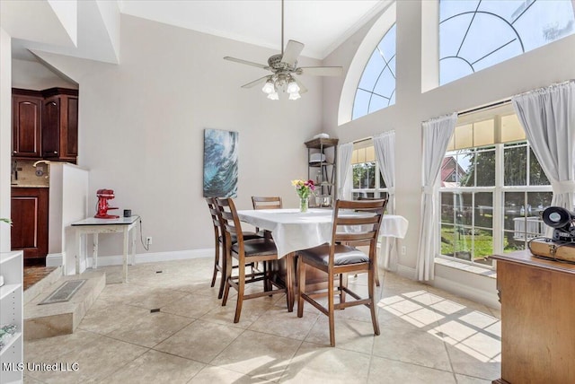 6313 Hermosa Dr, Ocean Springs, MS 39564 - dining space featuring a high ceiling, a ceiling fan, light tile patterned floors, baseboards, and ornamental molding