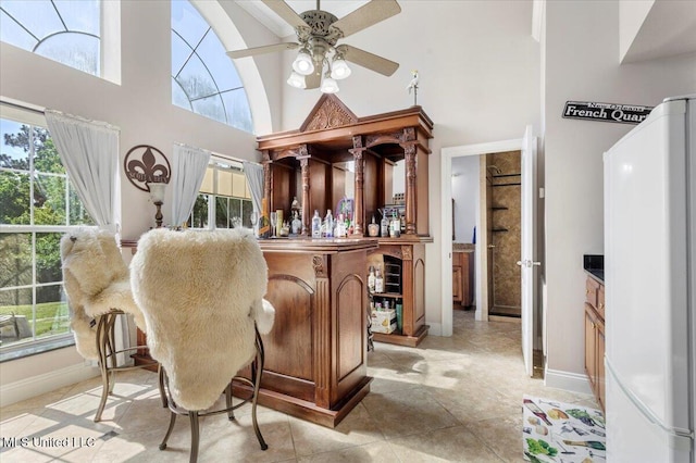 6313 Hermosa Dr, Ocean Springs, MS 39564 - indoor dry bar featuring freestanding refrigerator, a high ceiling, ceiling fan, baseboards, and light tile patterned floors