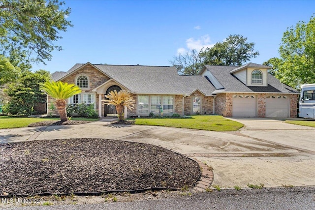 6313 Hermosa Dr, Ocean Springs, MS 39564 - view of front facade with curved driveway, a front lawn, stone siding, roof with shingles, and brick siding