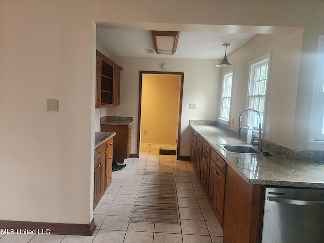 kitchen featuring pendant lighting, dishwasher, sink, and light tile patterned floors