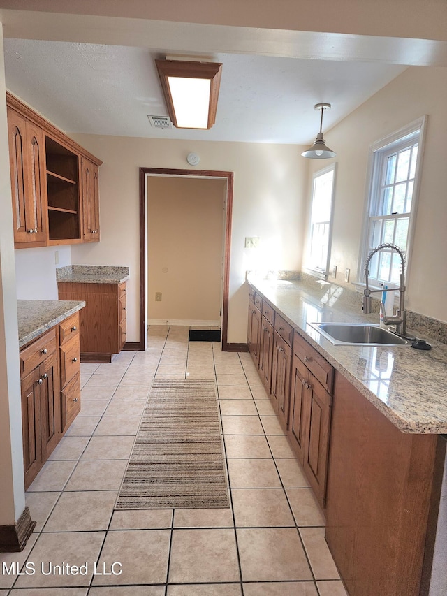 1618 Pear Orchard Pl, Jackson, MS 39211 - kitchen with light tile patterned floors, brown cabinetry, visible vents, open shelves, and a sink