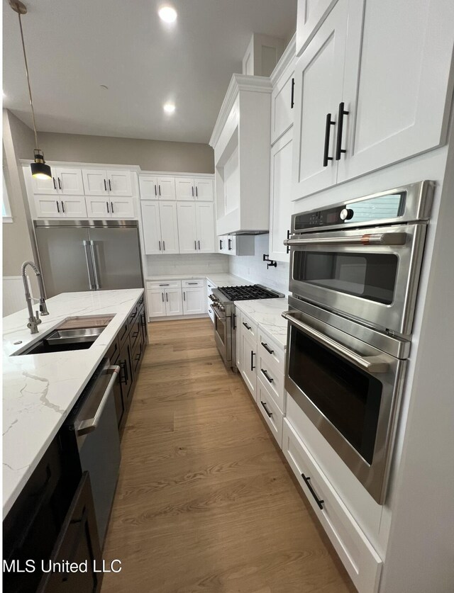 1851 Beach Blvd Unit 4, Biloxi, MS 39531 - kitchen with a sink, premium appliances, white cabinets, recessed lighting, and light stone countertops
