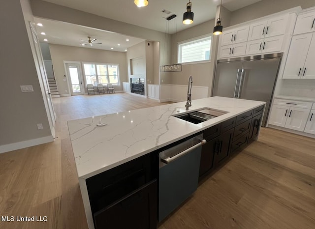 1851 Beach Blvd Unit 4, Biloxi, MS 39531 - kitchen with appliances with stainless steel finishes, a sink, open floor plan, light wood-style floors, and white cabinetry