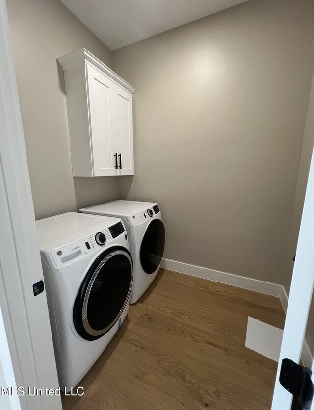 1851 Beach Blvd Unit 4, Biloxi, MS 39531 - laundry room with washing machine and clothes dryer, wood finished floors, cabinet space, and baseboards