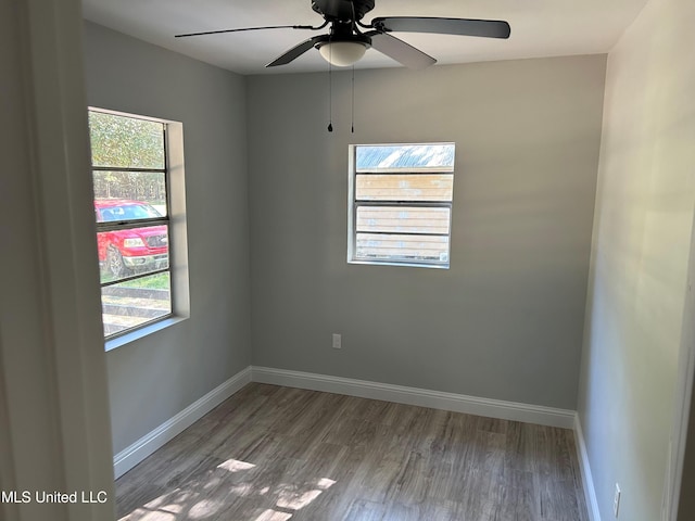 spare room featuring plenty of natural light, ceiling fan, and wood-type flooring