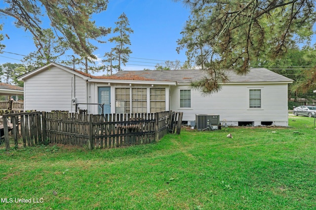 rear view of house featuring central AC, a yard, and a sunroom