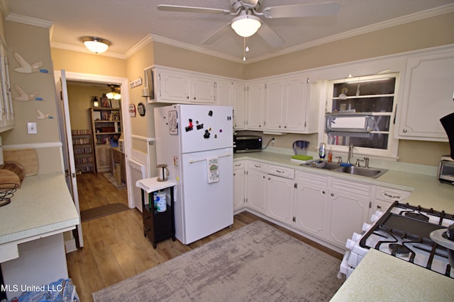 kitchen featuring sink, white cabinetry, white appliances, and light hardwood / wood-style floors