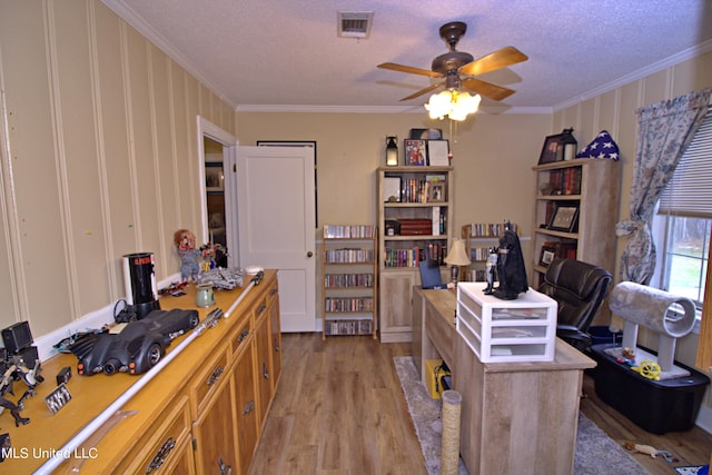 office area with crown molding, a textured ceiling, light wood-type flooring, and ceiling fan