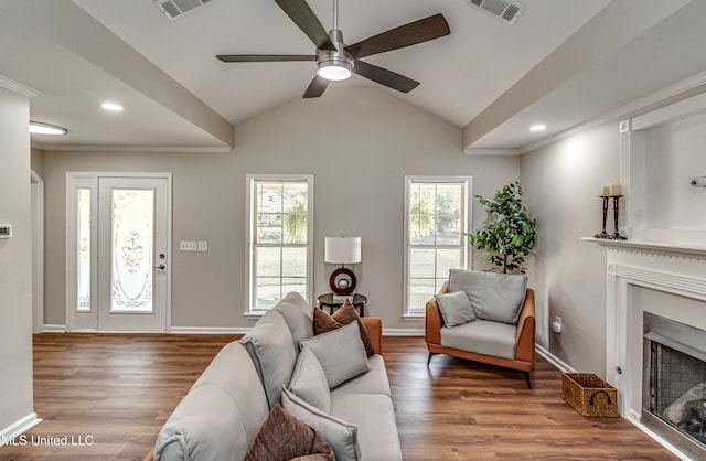 living area featuring visible vents, plenty of natural light, a fireplace, and wood finished floors