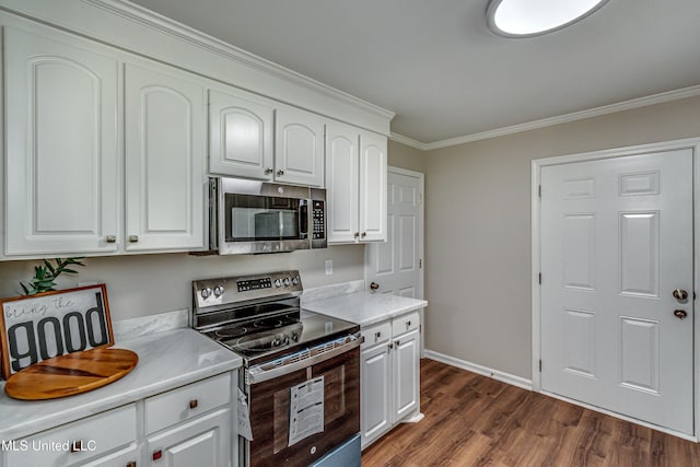 kitchen with light countertops, crown molding, dark wood-style flooring, and appliances with stainless steel finishes