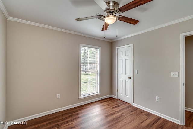 empty room featuring wood finished floors, baseboards, and ornamental molding