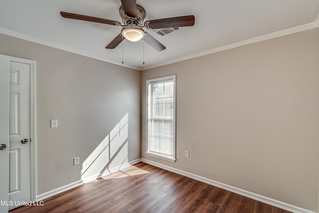 empty room featuring dark wood finished floors, baseboards, and ornamental molding