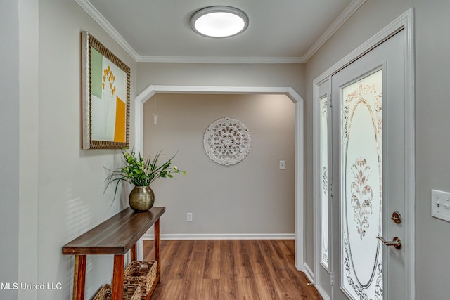 entryway with baseboards, wood finished floors, and crown molding