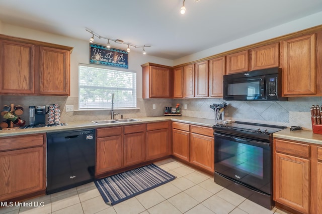 kitchen featuring brown cabinetry, a sink, and black appliances