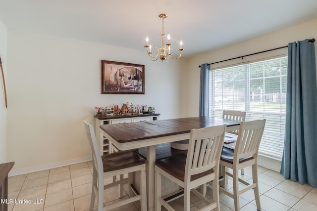 dining area with baseboards, a notable chandelier, and light tile patterned floors
