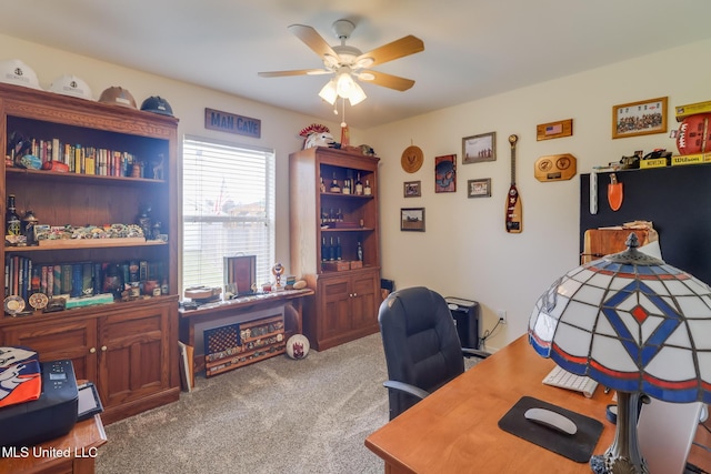 carpeted office space featuring ceiling fan