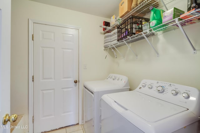 laundry room featuring separate washer and dryer, laundry area, and light tile patterned floors