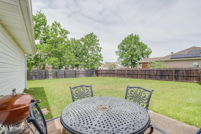 view of yard with a patio, a fenced backyard, and outdoor dining space