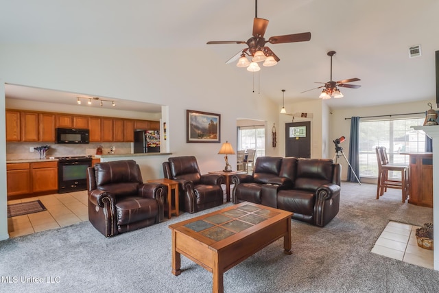living room with a wealth of natural light, light carpet, ceiling fan, and visible vents