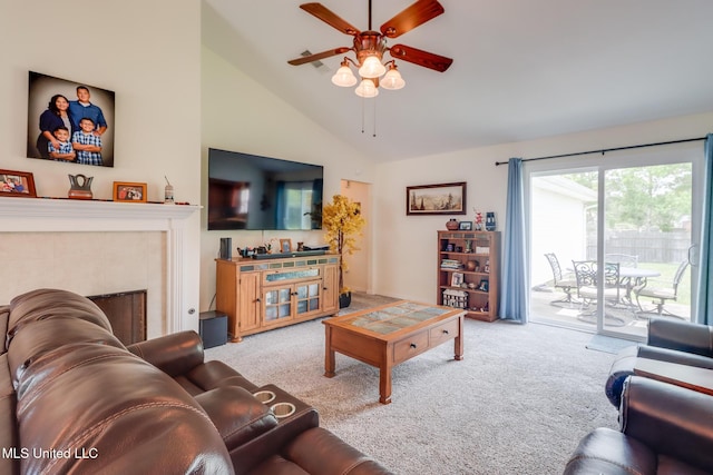 carpeted living area with ceiling fan, high vaulted ceiling, and a tile fireplace
