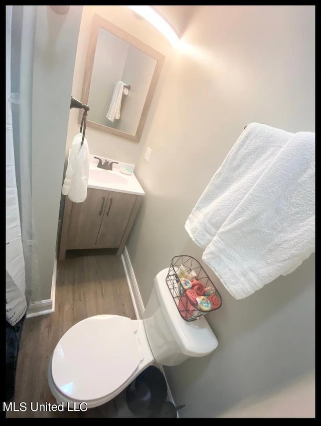 bathroom featuring vanity, hardwood / wood-style floors, and toilet