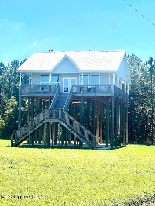 rear view of property featuring a wooden deck and a yard