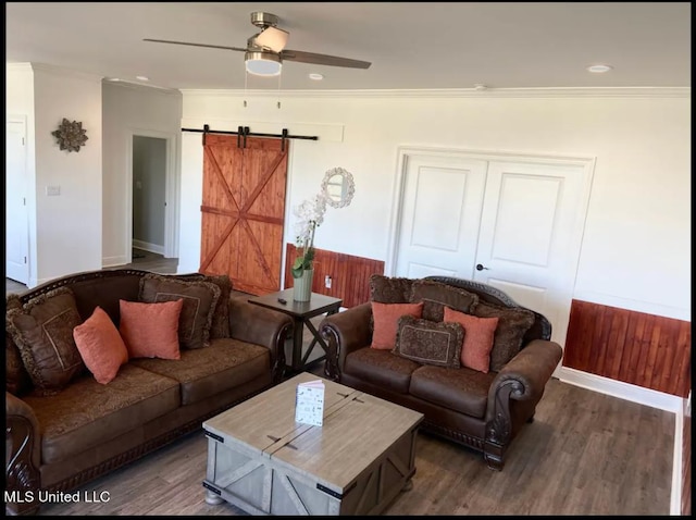 living room featuring ceiling fan, crown molding, dark hardwood / wood-style flooring, and a barn door