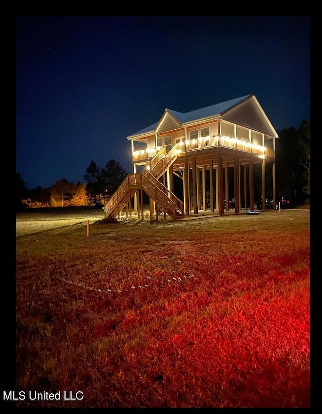 back house at twilight featuring a lawn