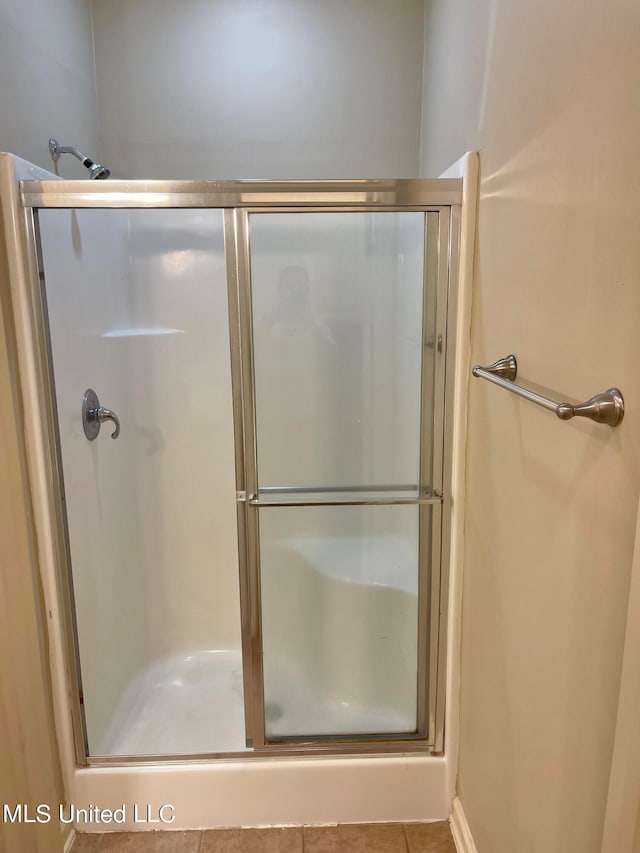 bathroom with tile patterned floors and a shower with shower door