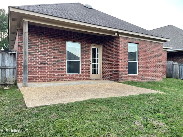 rear view of house featuring a patio area and a lawn