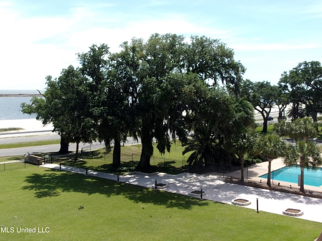 view of community featuring a swimming pool, a lawn, and a water view