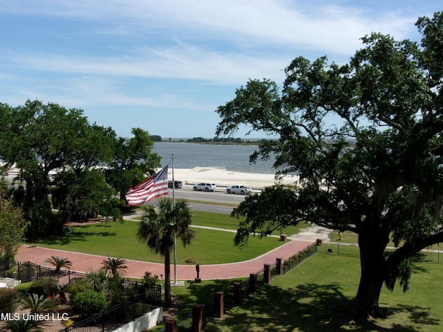 surrounding community featuring a water view and a yard