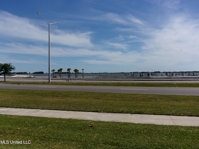 view of home's community featuring a lawn and a water view