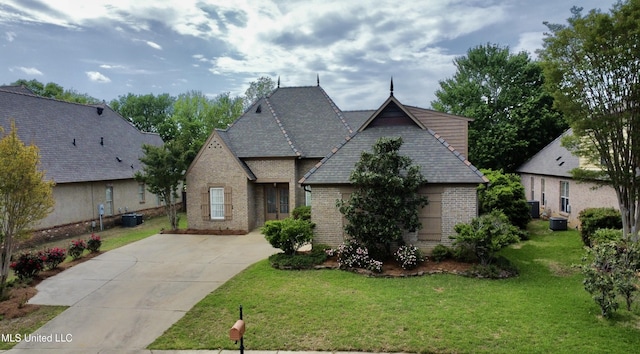 109 Brisage Dr, Madison, MS 39110 - view of front of home with a front yard, a shingled roof, central air condition unit, concrete driveway, and brick siding