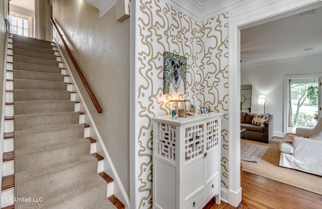 stairs with hardwood / wood-style flooring and ornamental molding