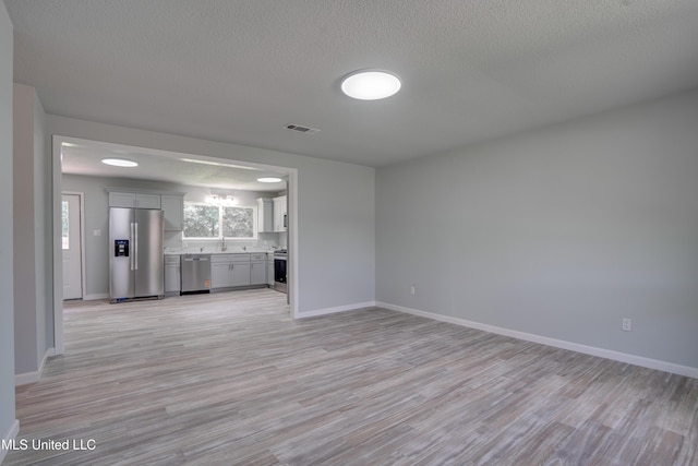 123 Darran St, Gulfport, MS 39503 - unfurnished living room featuring light wood-style floors and a textured ceiling