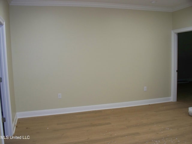 empty room with ornamental molding and light wood-type flooring