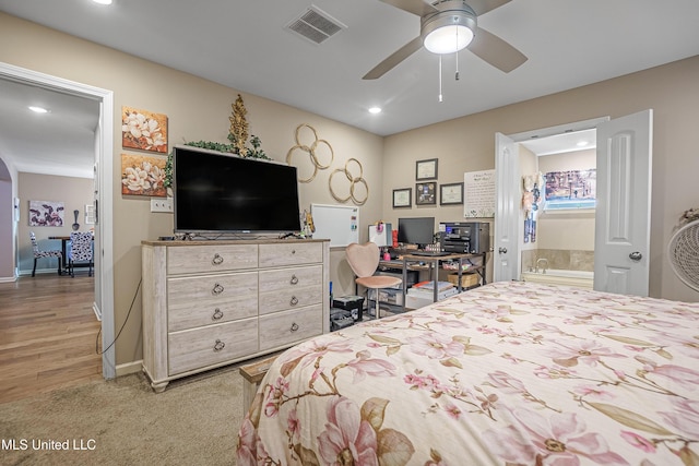 carpeted bedroom featuring ceiling fan and ensuite bath