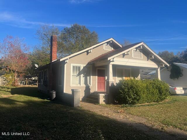 106 Beatrice St, Greenwood, MS 38930 - view of front of house with a chimney and a front yard