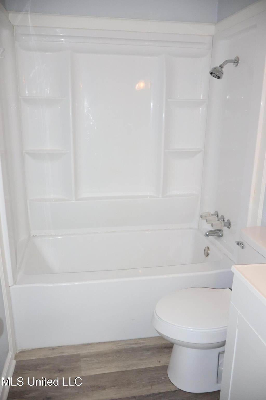 full bath with toilet, vanity,  shower combination, and wood finished floors