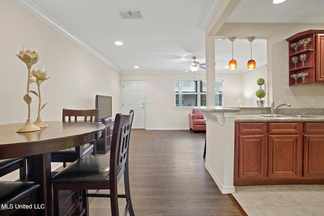 kitchen with light hardwood / wood-style flooring, hanging light fixtures, sink, crown molding, and ceiling fan